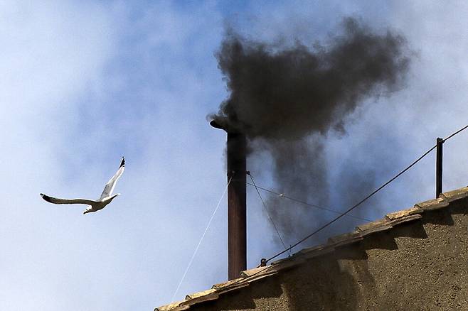 8일(현지시각) 오전 새로운 교황을 뽑기 위해 추기경단이 모여있는 이탈리아 바티칸 시스티나 경당 위 굴뚝에서 검은 연기가 피어올랐다. 교황을 건출하지 못했다는 의미다. EPA 연합뉴스