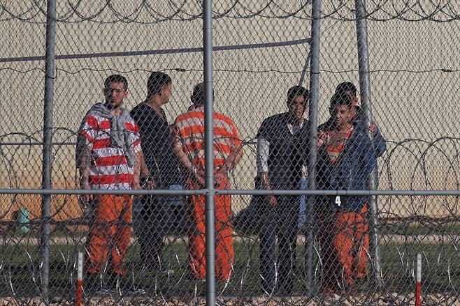 22일(현지시간) 미국 텍사스주 앤손에 있는 블루보넷 구치소에 구금된 베네수엘라 국적 이민자들이 울타리 뒤에 서있다. 로이터연합뉴스