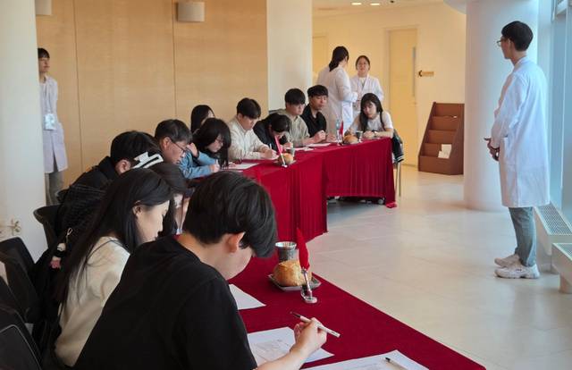 리펜트하우스 방탈출 게임 마지막 공간인 14층에 도착한 청년들이 삶의 주권을 하나님께 드리는 '명의 이전' 결단서를 쓰고 있다.