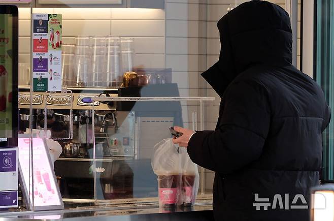 [서울=뉴시스] 이영환 기자 = 서울 시내의 더벤티 매장에서 한 고객이 아이스아메리카노를 구매하고 있다. 2025.02.21. 20hwan@newsis.com