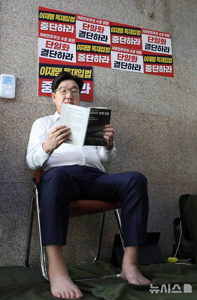 [서울=뉴시스] 고승민 기자 = 당 대선 후보 단일화 등을 촉구하며 단식 농성에 돌입한 권성동 국민의힘 원내대표가 8일 오전 서울 여의도 국회 원내대표실 앞에서 책을 읽고 있다. 2025.05.08. kkssmm99@newsis.com