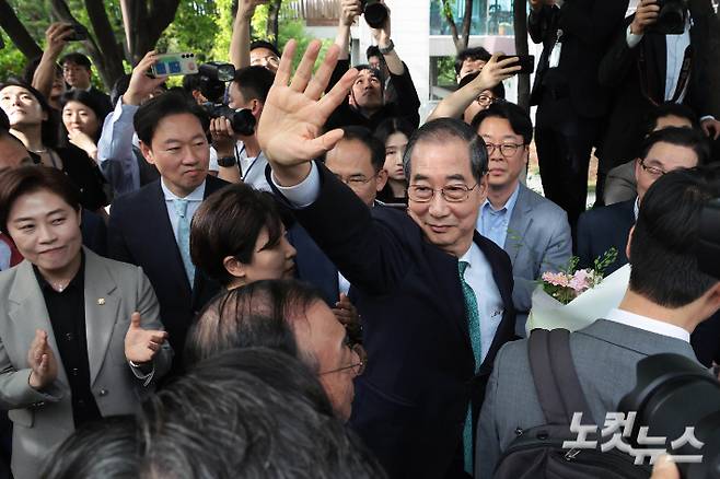 한덕수 무소속 대선 예비후보가 8일 오후 서울 여의도 국회 강변서재에서 열린 김문수 국민의힘 대선 후보와 단일화 관련 회동에 참석하며 김문수 지지자들을 향해 손을 들어 인사하고 있다. 황진환 기자