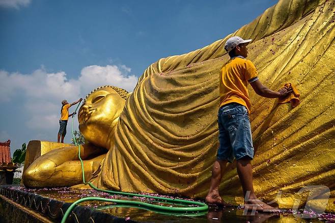 부처의 탄생과 깨달음 죽음을 기념하는 베삭 축제를 앞둔 7일(현지시간) 인도네시아 모조케르토의 마하 비하라 모조파히트 사원에서 인부들이 불상을 청소하고 있다. ⓒ AFP=뉴스1
