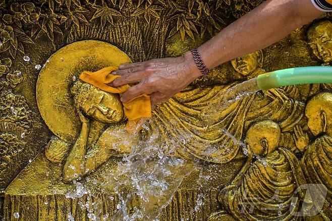 베삭 축제를 앞둔 7일(현지시간) 인도네시아 모조케르토의 마하 비하라 모조파히트 사원에서 인부들이 불상을 청소하고 있다. ⓒ AFP=뉴스1