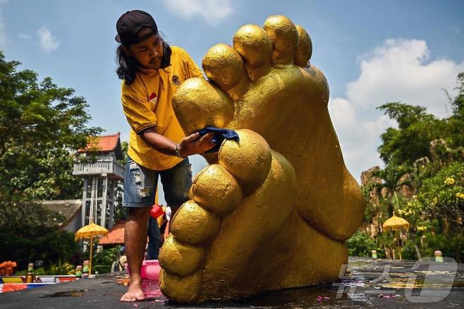 베삭 축제를 앞둔 7일(현지시간) 인도네시아 모조케르토의 마하 비하라 모조파히트 사원에서 인부들이 불상을 청소하고 있다. ⓒ AFP=뉴스1