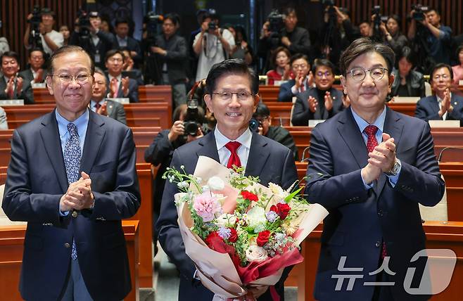 김문수 국민의힘 대통령 후보가 9일 서울 여의도 국회에서 열린 의원총회에서 꽃다발을 받은 뒤 기념 촬영하고 있다. 왼쪽부터 권영세 비대위원장, 김 후보, 권성동 원내대표. 김 후보는 지도부를 향해 "무소속을 당 후보 만들려 불법부당 수단 동원, 중단하라＂며 입장을 밝힌 뒤 의총장을 떠났다. 2025.5.9/뉴스1 ⓒ News1 안은나 기자