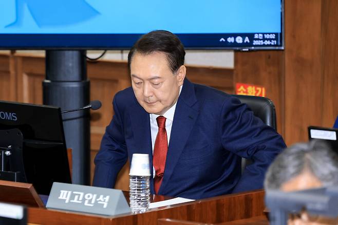 ‘내란 우두머리’ 피고인 윤석열이 2025년 4월21일 서울 서초구 서울중앙지법에서 열린 재판에 출석해 피고인석에 앉고 있다. 사진공동취재단