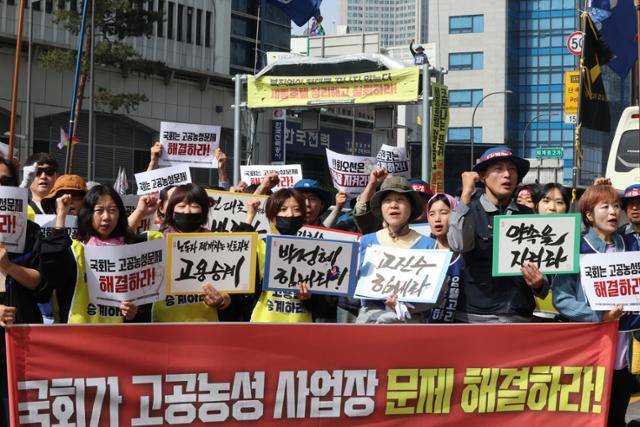 한국옵티칼하이테크지회, 세종호텔지부, 거제통영고성조선하청지회 등 고공농성 3개 사업장의 조합원들이 8일 서울 명동 세종호텔 고공농성장 앞에서 국회를 향해 고공농성 사업장 문제 해결을 촉구하고 있다. 뒷편에 보이는 10여m 높이의 지하차도 진입차단시설 위에서 고진수 세종호텔지부장은 올해 2월 13일부터 9일까지 86일째 고공농성 중이다. 연합뉴스