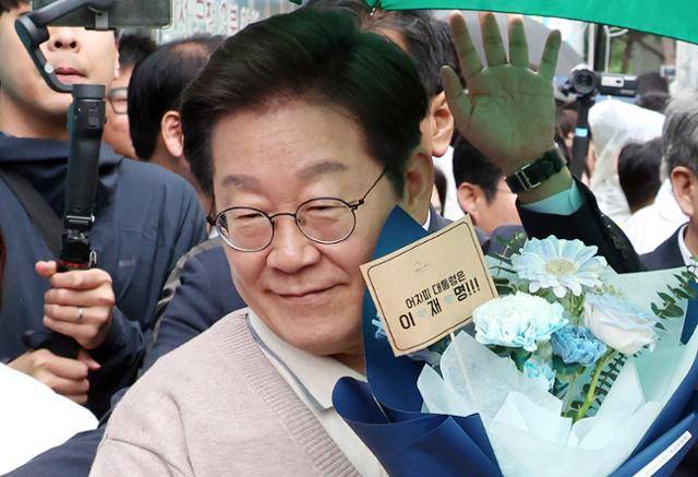 민심을 청취하는 '경청 투어'에 나선 이재명 더불어민주당 대선 후보가 9일 경북 칠곡군 석적읍 인근에서 한 지지자로부터 꽃다발을 받아 들고 있다. 칠곡=뉴시스