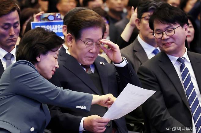 [서울=뉴시스] 조성우 기자 = 이재명(가운데) 더불어민주당 대선후보가 8일 오후 서울 여의도 중소기업중앙회에서 열린 중앙선대위 직능본부 민생정책 협약식에서 자료를 보고 있다. 왼쪽은 남인순 직능본부장. 2025.05.08. /사진=조성우