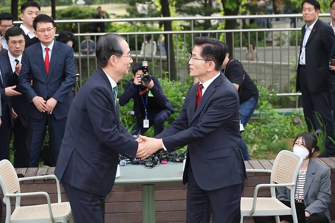 김문수 국민의힘 대선후보와 한덕수 무소속 대선 예비후보가 8일 서울 국회 사랑재에 위치한 커피숍에서 회동을 마친 후 악수하고 있다. [연합]