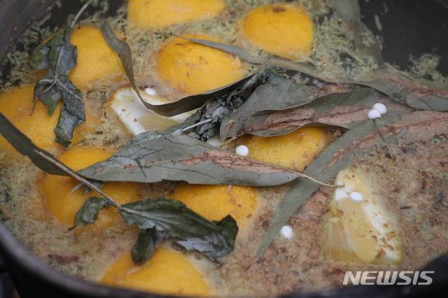 [산티아고=AP/뉴시스]1일(현지시간) 칠레 수도 산티아고 산 베르나르도 근교의 무료 급식소에서 한 자원봉사자가 마시면 신종 코로나바이러스 감염증(코로나19)에 걸리지 않는다고 알려진 차를 만들고 있다. 이 차는 레몬, 생강, 유칼립투스, 아스피린 등을 넣어 만든다. 2020.07.02.