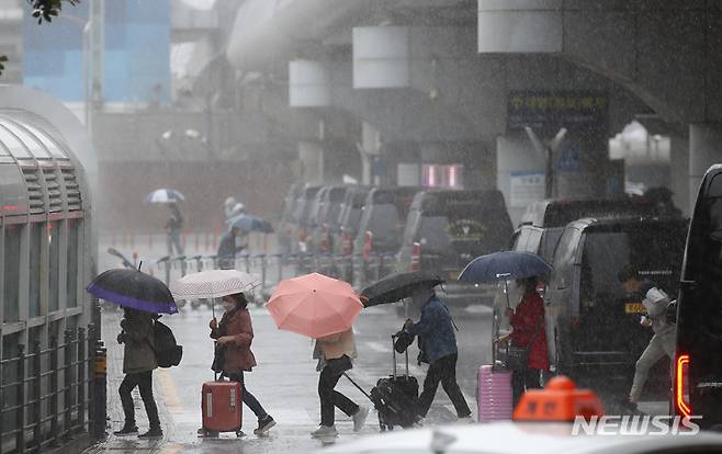 [제주=뉴시스] 우장호 기자 = 제주국제공항 1층 도착장에 우산을 쓴 관광객들이 발걸음을 재촉하고 있다. (사진=뉴시스DB) woo1223@newsis.com