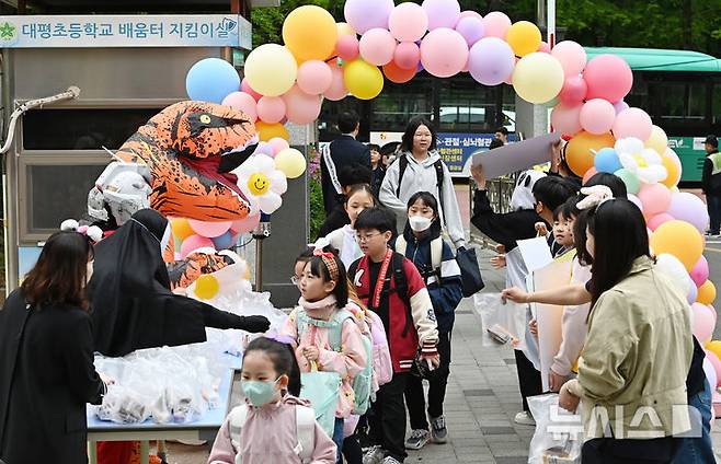 [수원=뉴시스] 김종택 기자 = 어린이날을 나흘 앞둔 지난 1일 경기 수원시 대평초등학교에서 등교하는 학생들이 학부모들이 준비한 선물을 전달 받고 있다. 2025.05.01. jtk@newsis.com