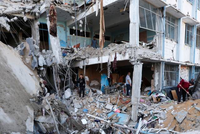 ▲7일(현지시간) 팔레스타인인들이 이스라엘 폭격으로 파괴된 가자지구 중부 부레이지 난민촌의 유엔팔레스타인난민기구(UNRWA) 학교 건물을 조사하고 있다. 이 건물엔 이스라엘 공격으로 난민이 된 주민들이 머물고 있었다. ⓒ로이터=연합뉴스