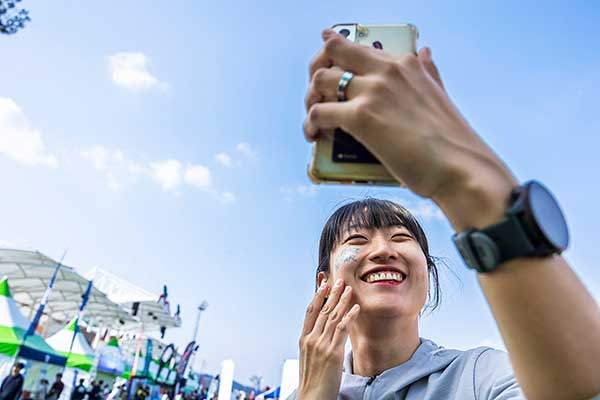 얼굴에 '스카르파' 스티커를 붙이고 재미있어 하는 한 참가자.