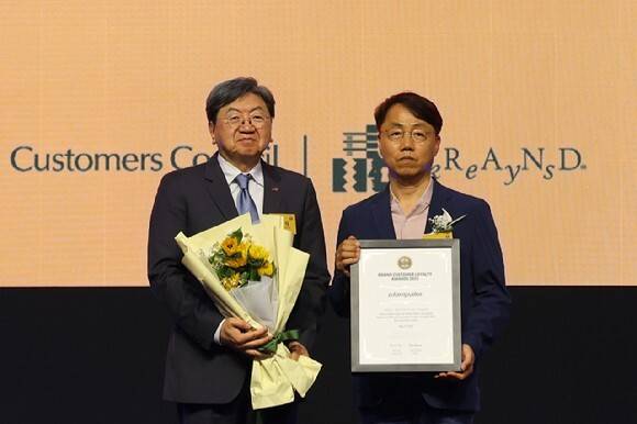 글램팜이 '브랜드 고객충성도 대상' 헤어스타일러 부문에서 4년 연속 1위를 차지했다. 하재진 언일전자 대표(오른쪽)가 수상하는 모습. 글램팜 제공