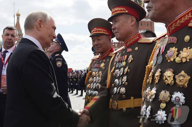 러시아의 블라디미르 푸틴 대통령(왼쪽)이 9일 모스크바 중심부의 붉은 광장에서 전승절 기념 열병식 후 북한 군인들과 만나는 모습. 러시아는 이날을 제2차 세계대전에서 소련이 나치 독일에 승리한 지 80주년이 된 날로 기념한다. 2025.5.9 ⓒ AFP=뉴스1 ⓒ News1 강민경 기자