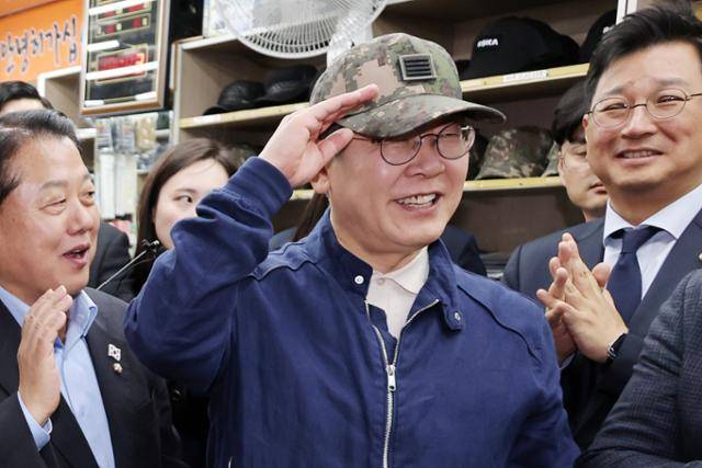 민심을 청취하는 '경청 투어'에 나선 이재명 더불어민주당 대선 후보가 2일 오후 강원도 화천군 화천공영버스터미널 인근의 한 군장점에서 김병주 최고위원이 사준 병장 계급장이 달린 육군 모자를 써보고 있다. 뉴시스