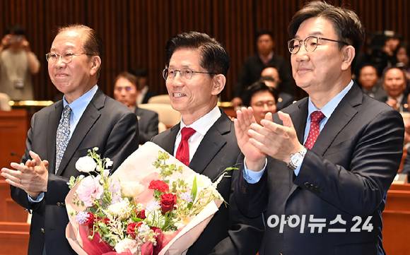 김문수 국민의힘 대선후보가 9일 서울 여의도 국회에서 열린 의원총회에서 꽃다발을 들고 권영세 비대위원장, 권성동 원내대표와 기념촬영을 하고 있다. [사진=곽영래 기자]