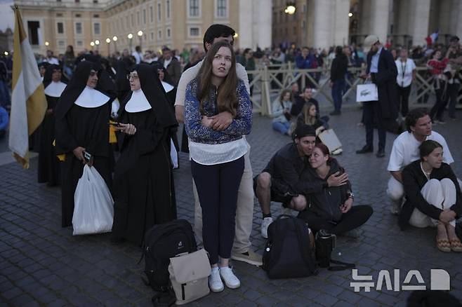 [바티칸=AP/뉴시스] 7일(현지 시간) 바티칸 시국 성 베드로 광장에 모인 사람들이 시스티나 성당 굴뚝에서 교황 선출 여부를 알리는 연기가 피어오르기를 기다리고 있다. 이날 제267대 교황을 선출하는 추기경들의 비밀회의 ‘콘클라베’ 첫 투표가 실시됐으며, 교황이 선출되지 않으면 굴뚝에서 검은 연기가, 선출되면 흰 연기가 피어올라 결과를 알린다. 2025.05.08.