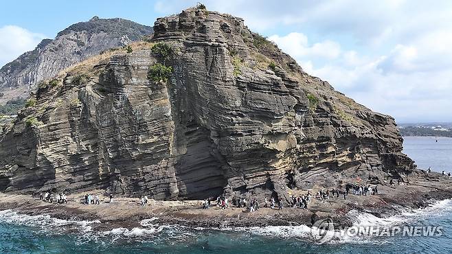 용머리해안 찾은 단체 탐방객들 (서귀포=연합뉴스) 박지호 기자 = 20일 오전 제주 서귀포시 안덕면 사계리 용머리해안을 찾은 관광객이 절경을 감상하며 산책하고 있다. 2025.3.20 jihopark@yna.co.kr