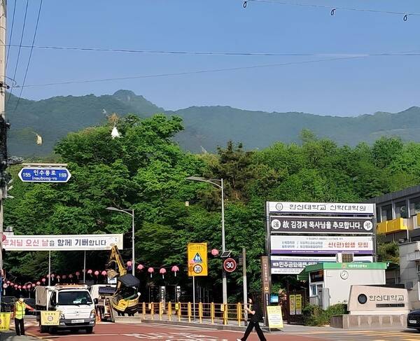 5월8일 서울 수유리 한신대 신학대학원 앞 풍경. 김경재 교수 추모현수막이 학교 교문에 걸려 있고, 화계사로 올라가는 골목길에는 한신대 신학대학원 학생회에서 내건 “부처님 오신 날을 함께 기뻐합니다” 현수막이 걸려있다. 한신대 신학대학원과 화계사는 석탄일과 성탄일에 서로를 축복하는 현수막을 골목에 걸어준다. 이 이벤트의 중심에는 김경재 교수님이 계셨다. 비록 님은 갔지만 여전히 수유리 신학대학원에는 그의 정신과 흔적이 짙게 배어 있다. 이상철 원장 제공