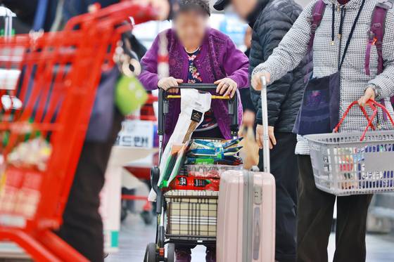 Customers shop for goods at a supermarket in Seoul on April 6. [YONHAP]