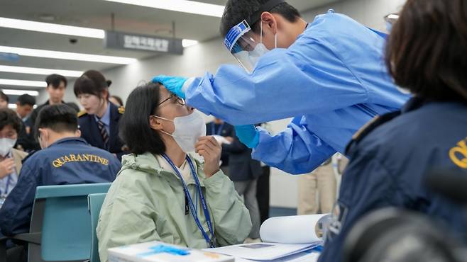 지난 8일 오후 부산 강서구 김해국제공항 검역소 역학조사관이 모의검역에 입국자로 참여한 국민소통단원 김옥련씨(70·여)의 검체를 채취하고 있다. /사진=질병관리청