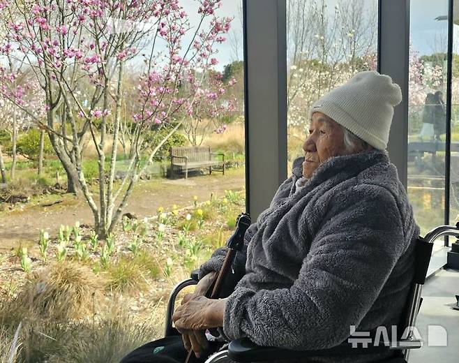 [제주=뉴시스] 임재영 기자 = 김춘부 할머니가 지난 3월30일 서귀포시 효돈동 '베케' 정원에서 1960년대부터 꽃밭을 만든 배경을 설명하고 나서 창밖을 바라보고 있다. 2025.05.11. ijy788@newsis.com