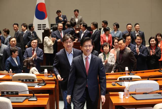 김문수 국민의힘 대선 후보가 11일 서울 여의도 국회에서 열린 의원총회에서 의원들과 기념 촬영을 한 후 권성동 원내대표와 밖으로 나서고 있다. 연합뉴스