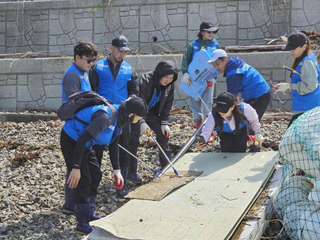 경남외국인주민지원센터 외국인봉사단이 지난 11일 반려해변인 통영 통시해변에서 해양정화활동을 펼치고 있다./경남외국인주민지원센터/