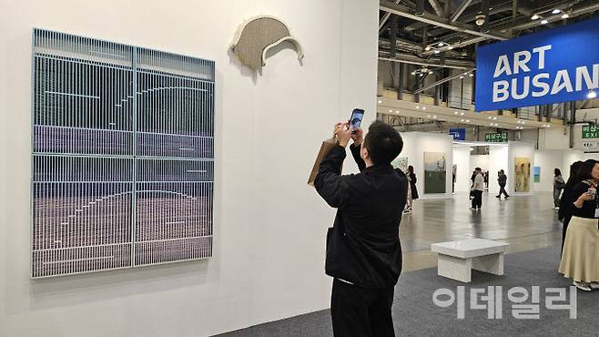 ‘아트부산 2025’ 전경. 한 관람객이 국제갤러리 부수에서 지난달 타계한 강서경 작가의 작품 ‘마운틴 ＃24-10’(2023∼2024 위), ‘매트 ＃24-07’(2023∼2024) 앞에 오래 머물렀다(사진=오현주 문화전문기자).