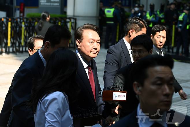 윤석열 전 대통령이 12일 오전 서울 서초구 중앙지방법원에서 열린 내란 우두머리 혐의, 직권남용 권리행사방해 혐의 사건 3차 공판에 출석, 취재진의 질문을 받으며 이동하고 있다. 2025.5.12/뉴스1 ⓒ News1 사진공동취재단