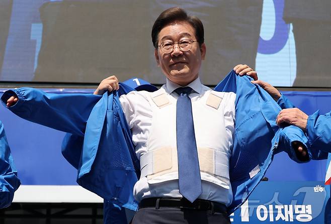 이재명 더불어민주당 대통령 후보가 제21대 대통령선거 공식 선거운동이 시작된 12일 오전 서울 종로구 광화문광장에서 열린 중앙선거대책위원회 출정식에서 방검복 위에 선거운동복을 입고 있다.(공동취재) 2025.5.12/뉴스1 ⓒ News1 안은나 기자