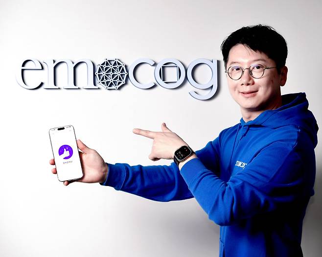 노유헌 이모코그 공동대표가 코그테라 앱 화면이 담긴 스마트폰을 들고 포즈를 취하고 있다. /조선비즈