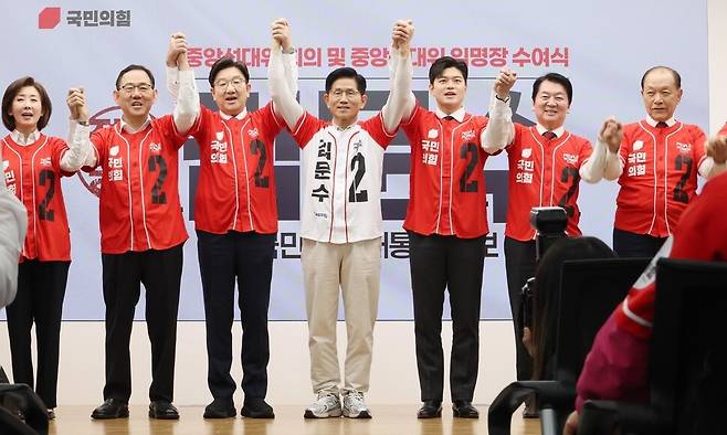 김문수 국민의힘 대통령 후보와 중앙선거대책위원장들이 12일 오전 서울 여의도 국민의힘 당사에서 열린 중앙선대위 출범식에서 손을 번쩍 들어올리고 있다. 공동취재사진