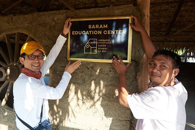 권태훈(왼쪽)씨가 지난 2020년 1월 미얀마 사가잉 지역 이고 마을에 ‘사람예술학교’ 간판을 걸고 있다.