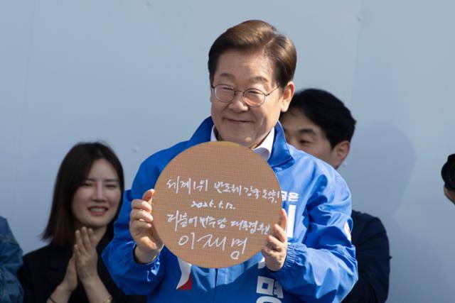 이재명 더불어민주당 대선 후보가 12일 오후 경기 화성시 동탄 센트럴파크 음악분수중앙광장에서 열린 ‘K반도체' 동탄 집중유세에서 반도체 웨이퍼에 서명을 한 후 들어보이고 있다. 고영권 기자