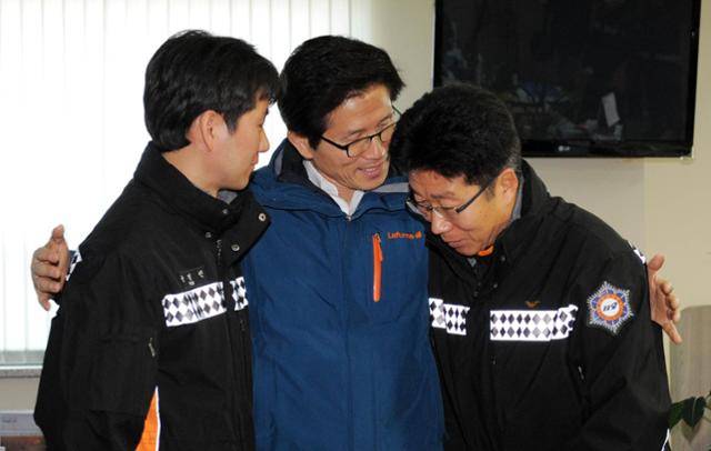 2011년 12월 19일 119전화 통화 갑질 논란으로 물의를 빚었던 김문수(가운데) 당시 경기지사가 같은 해 12월 30일 경기 남양주 소방서를 찾아 당시 전화를 받아 타 지역으로 전보조치됐다가 원대복귀한 소방관들을 만나 대화 후 기념촬영을 하고 있다. 해당 소방관들이 어색한 듯 서로 다른 곳을 보고 있다. 한국일보 자료사진
