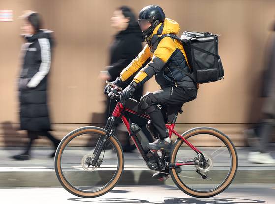 지난 2월 서울 한 도로에서 배달노동자가 점심시간 음식을 배달하는 모습. 뉴스1