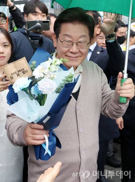 [칠곡=뉴시스] 조성우 기자 = 민심을 청취하는 '경청 투어'에 나선 이재명 더불어민주당 대선후보가 9일 경북 칠곡군 석적읍 인근에서 한 지지자로부터 꽃다발을 받고 있다. 2025.05.09. xconfind@newsis.com /사진=조성우