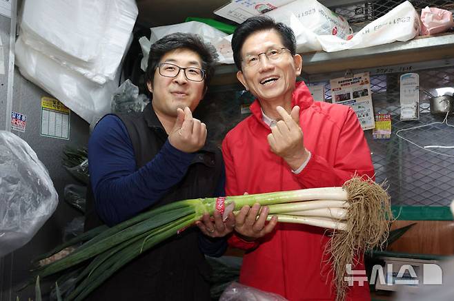 [서울=뉴시스] 권창회 기자 = 제21대 대통령선거 공식 선거운동 첫날인 12일 오전 김문수 국민의힘 대선 후보가 서울 송파구 가락시장을 방문해 대파를 구매하며 기념촬영을 하고 있다. 2025.05.12. kch0523@newsis.com