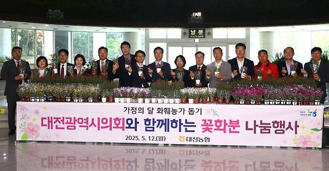 [대전=뉴시스] 조명휘 기자 = NH농협은행 대전본부가 가정의 달을 맞아 12일 지역 화훼농가를 돕고 꽃소비 문화를 확산하기 위해 시의회에서 꽃화분 나눔행사를 열고 있다. (사진= 농협대전본부 제공) 2025.05.12. photo@newsis.com *재판매 및 DB 금지