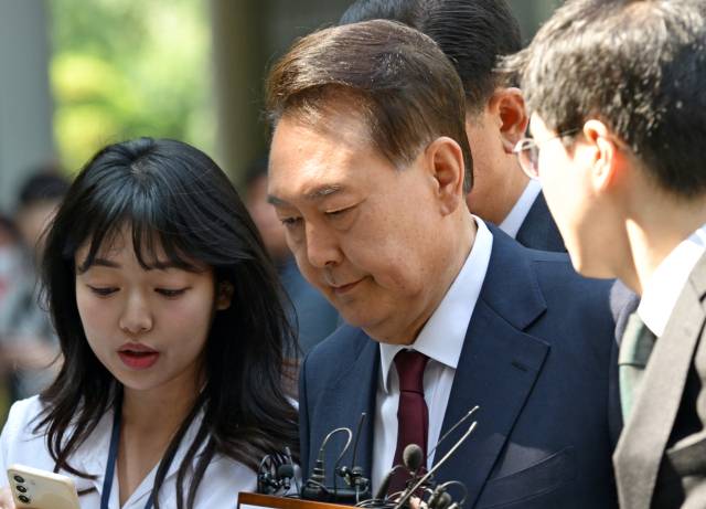 ▲윤석열 전 대통령이 12일 서울 서초구 중앙지방법원에서 열린 내란 우두머리 혐의·직권남용 권리행사방해 혐의 사건 3차 공판에 출석, 취재진의 질문을 받으며 이동하고 있다. ⓒ연합뉴스