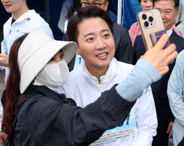 개혁신당 이준석 대선 후보가 11일 부산 해운대구 벡스코 일대에서 열린 다이아몬드브릿지 걷기축제에 참가해 시민들과 사진을 찍고 있다. 연합뉴스