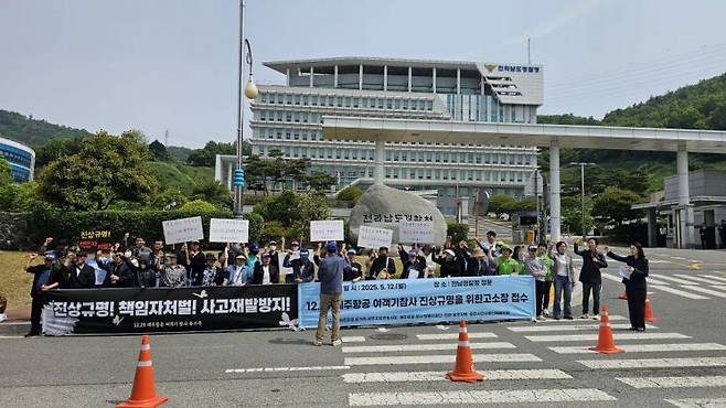 제주항공 참사 유가족들이 13일 전남경찰청 앞에서 진상규명과 책임자 처벌을 촉구하며 고소장을 접수하고 있다. 유가족 제공