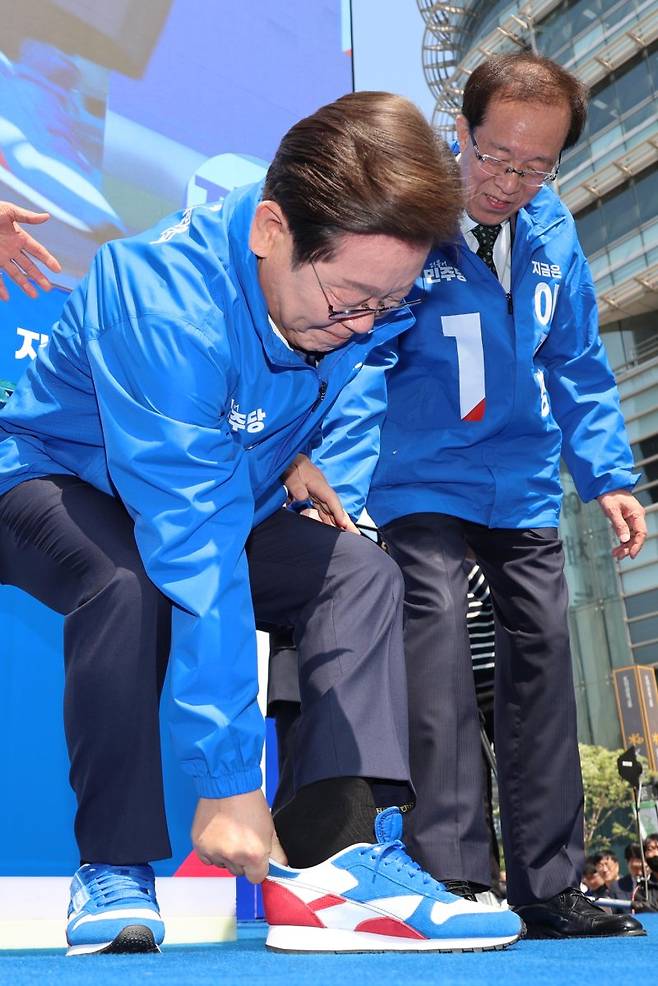 이재명 더불어민주당 대선후보가 제21대 대통령선거 공식 선거운동이 시작된 12일 오전 서울 청계광장에서 열린 중앙선거대책위원회 출정식 및 첫 유세에서 구두를 벗고 운동화로 갈아 신고 있다. /사진=뉴시스