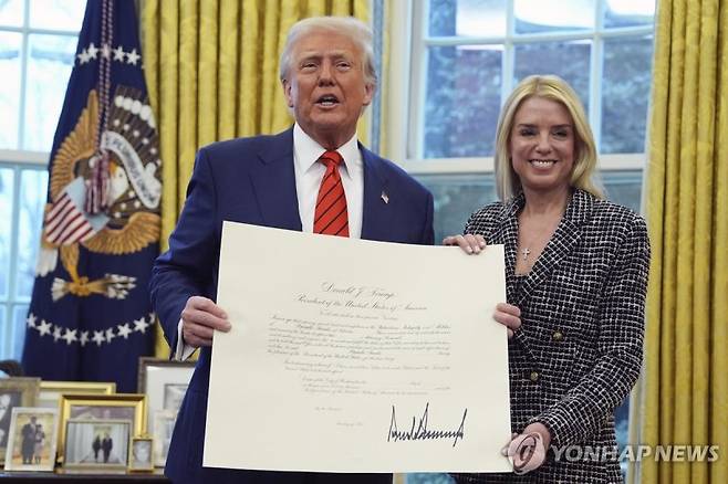 도널드 트럼프 미국 대통령이 최근 행정 명령에 사인한 뒤 이를 자랑스럽게 펼쳐 보이고 있다. 연합뉴스