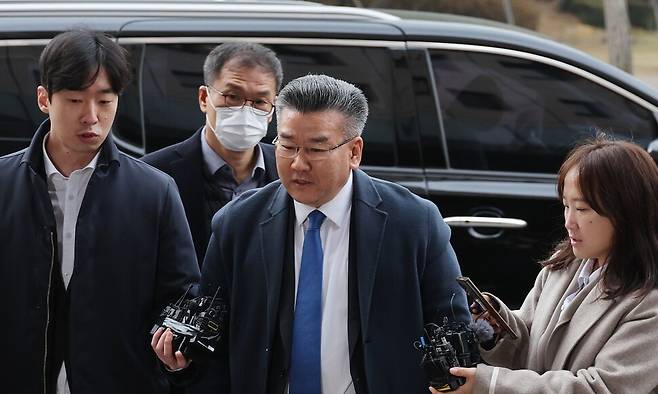 전현희 전 국민권익위원장에 대한 ‘표적 감사’ 주도 의혹을 받는 유병호 감사원 감사위원(당시 사무총장)이 2023년 12월9일 오전 경기도 과천시 고위공직자범죄수사처(공수처)에 도착해 취재진의 질문을 받고 있다. 당시는 휴일이었지만 감찰과와 특별조사국 직원들이 다수 유병호 당시 사무총장을 배웅하러 공수처를 찾았다. 유 감사위원 뒤에 있는 두명은 홍현식 특별조사국 5과장(왼쪽)과 김숙동 특별조사국장(오른쪽). 신소영 기자 viator@hani.co.kr